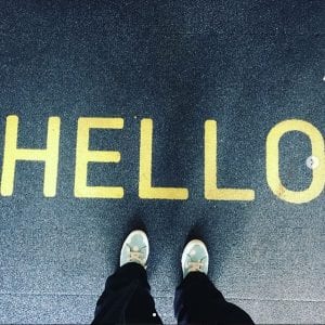 student's feet below the word 'hello'