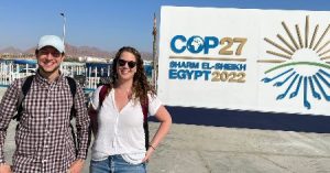 2 researchers standing in front of the COP27 sign in Egypt